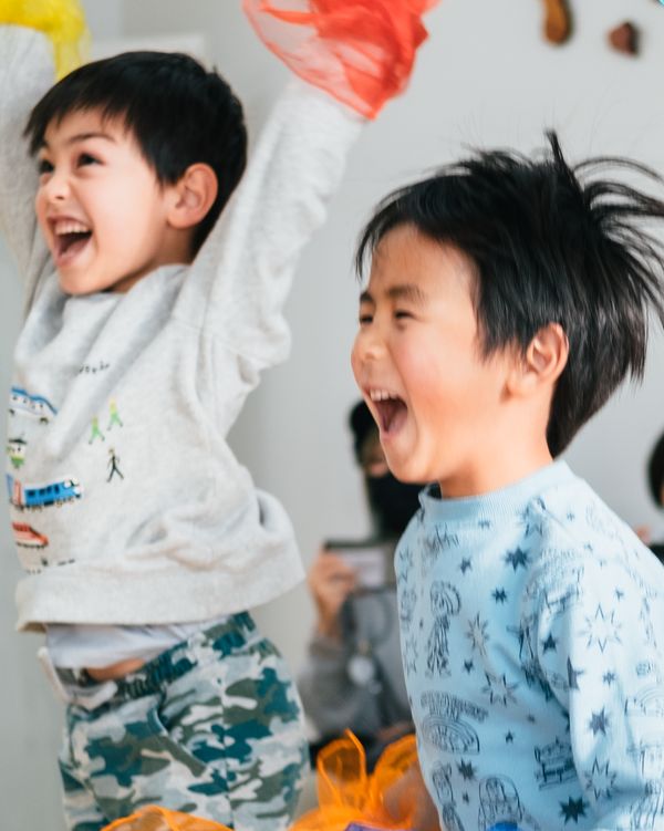 布を持って笑顔でジャンプする子どもたち